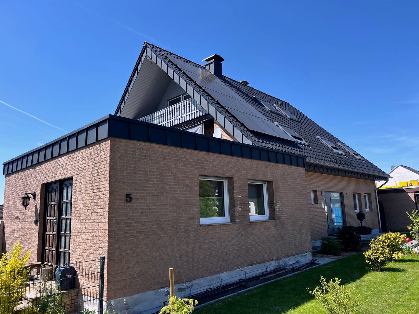 Fertig eingedecktes Steildach mit Photovoltaik und anthrazitfarbener Attika-Verblendung